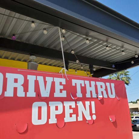Coronavirus sights. A "Drive Thru Open" banner sign outside a restaurant in USA.