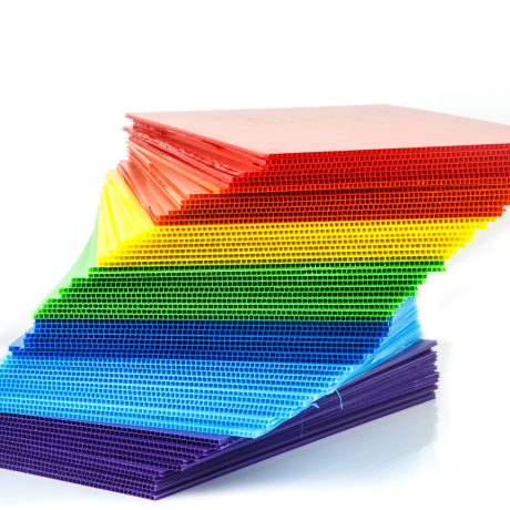 Stack of colorful  corrugated plastic sheets on white