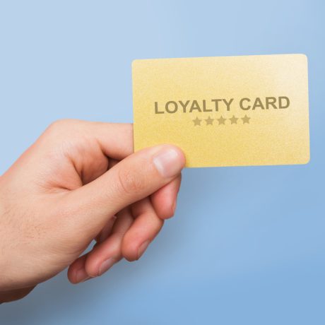 Marketing and client relations concept. Young guy showing loyalty card on blue background, close up of hand. Collage